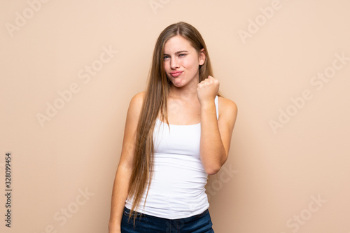 Teenager blonde girl over isolated background with angry gesture