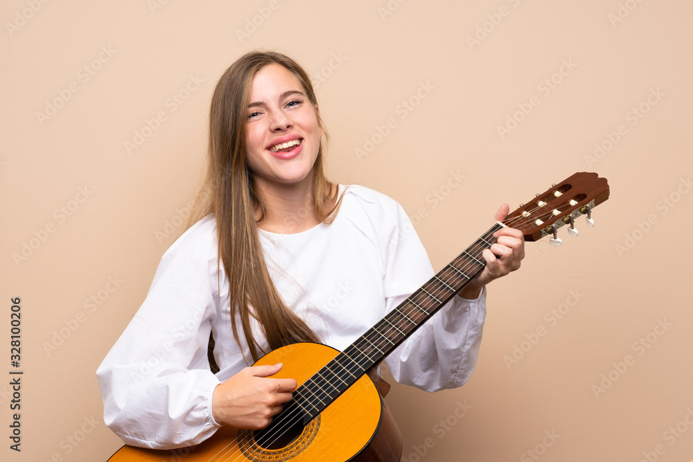Fototapeta premium Teenager girl with guitar over isolated background