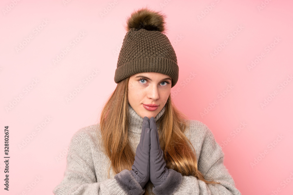 Young teenager girl with winter hat over isolated pink background pleading Young teenager girl with winter hat over isolated pink background pleading