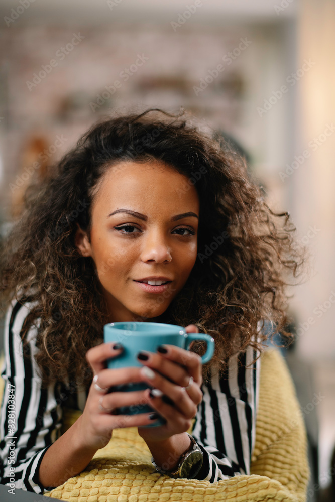 Young beautiful woman enjoying her coffee. African woman drinking coffee. 
