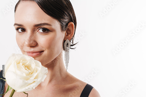 Image of charming young pretty woman smiling and holding white flower