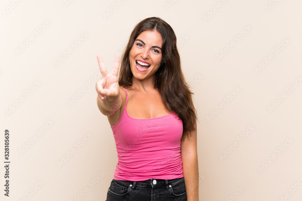 Young woman over isolated white background smiling and showing victory sign Young woman over isolated white background smiling and showing victory sign