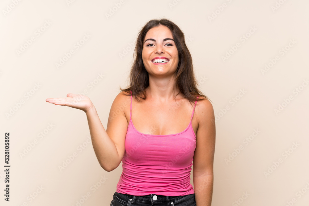 Young woman over isolated white background holding copyspace imaginary on the palm to insert an ad Young woman over isolated white background holding copyspace imaginary on the palm to insert an ad