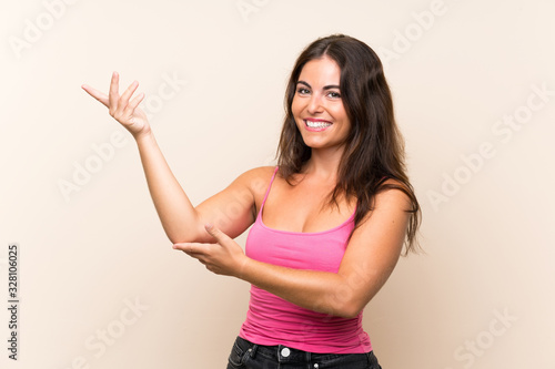 Young woman over isolated white background extending hands to the side for inviting to come