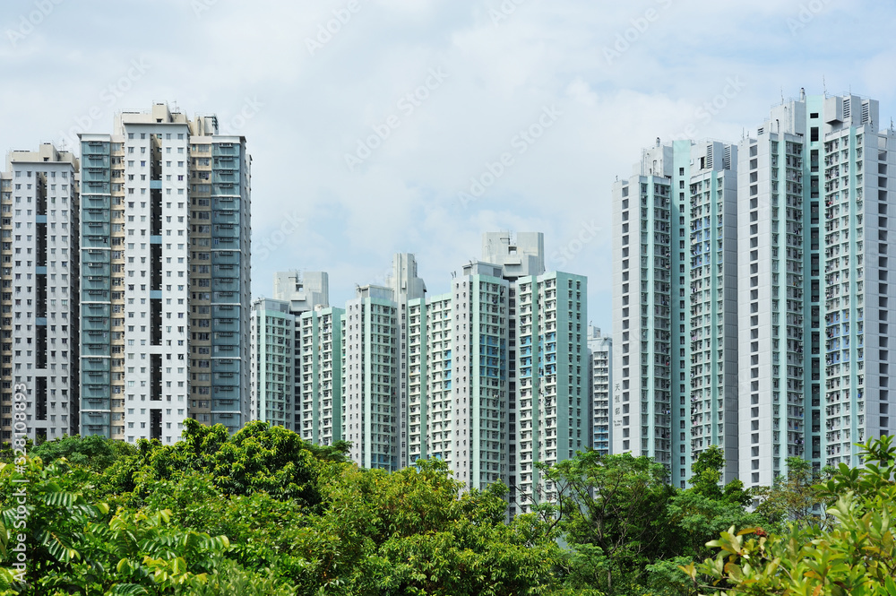 High-rise Residential Apartment Buildings under Cloudy Sky with Trees as Foreground in Tian Shui Wai Town, Yuen Long District, Hong Kong in July 2016