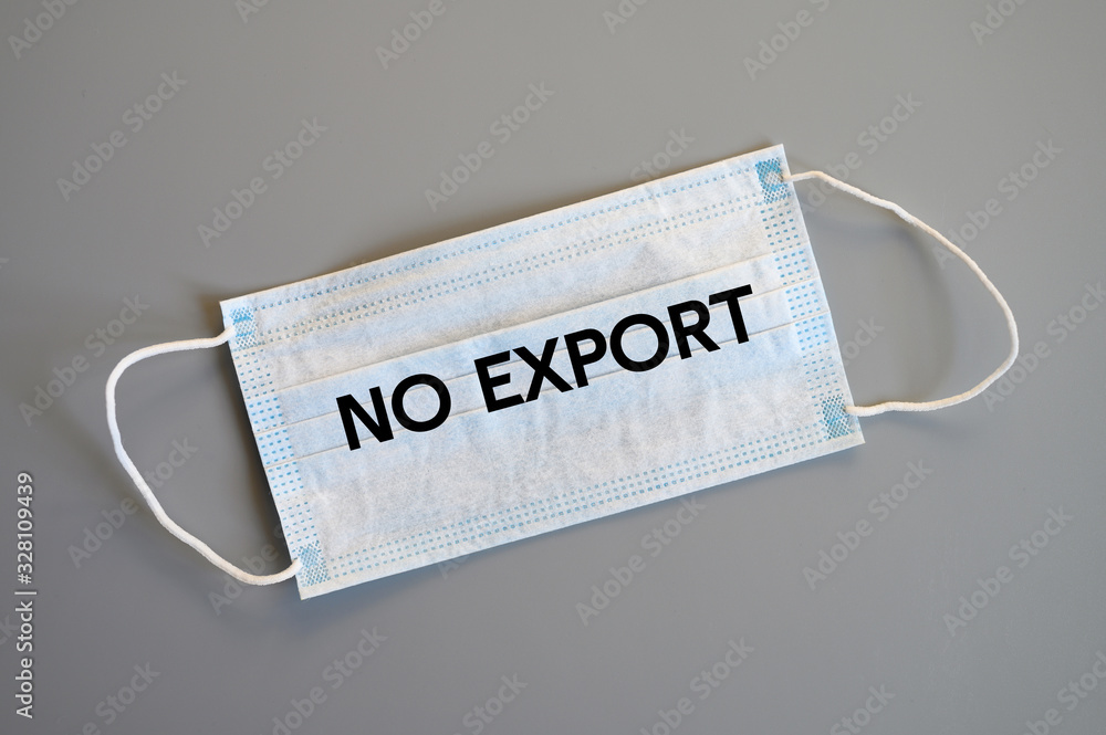 no export text on a blue or white medical protective mask on gray background, ban on export of masks that protect coronavirus covid-19 from China. top view, flat lay, isolated, nobody. ofl font no export text on a blue or white medical protective mask on gray background, ban on export of masks that protect coronavirus covid-19 from China. top view, flat lay, isolated, nobody. ofl font