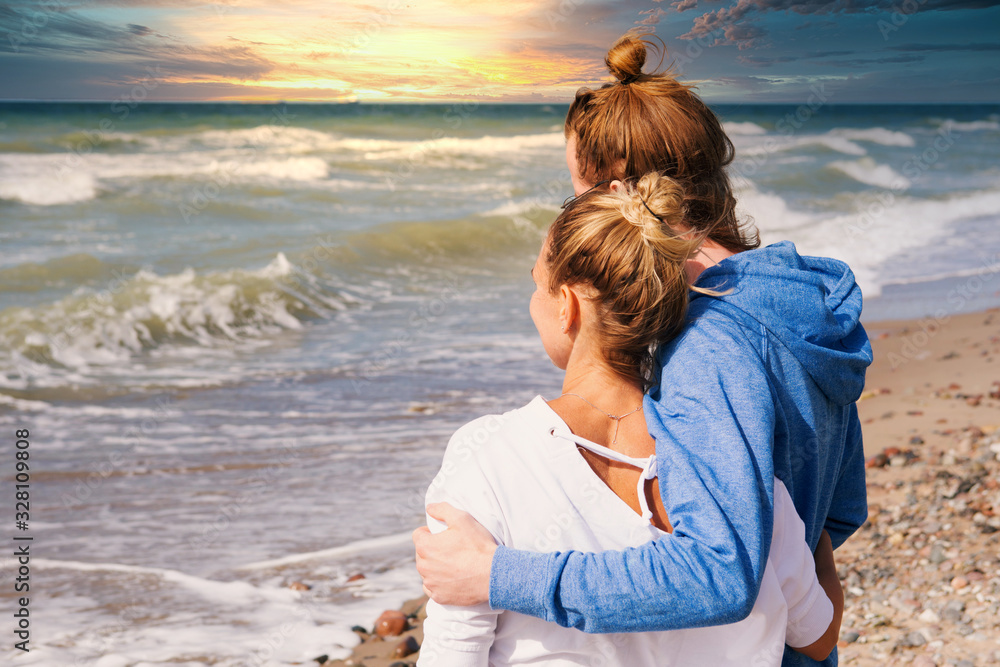 young couple hugging each other by the ocean