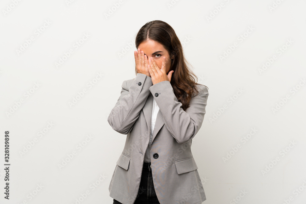 Young business woman over isolated white background covering eyes and looking through fingers Young business woman over isolated white background covering eyes and looking through fingers