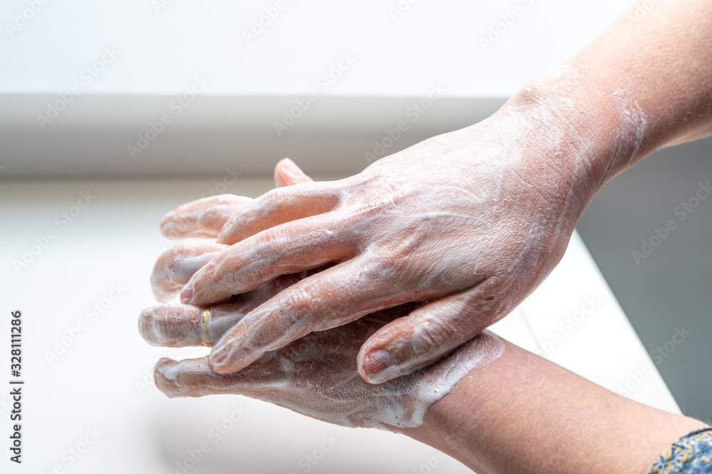Fototapeta premium Woman washing her hands to avoid diseases like coronavirus