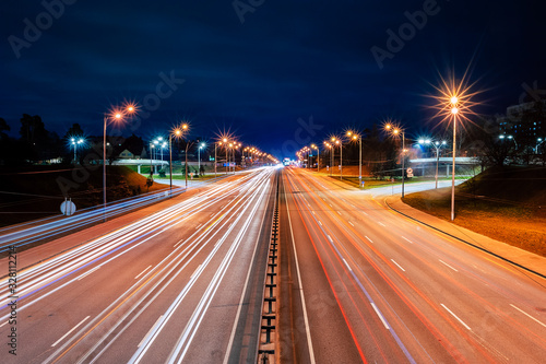 bright lights from cars and street lamps on the highway at night