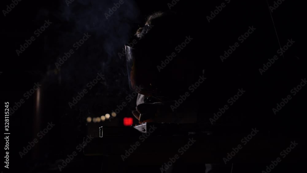 Man Welding inside dark studio in slow motion Man Welding inside dark studio in slow motion