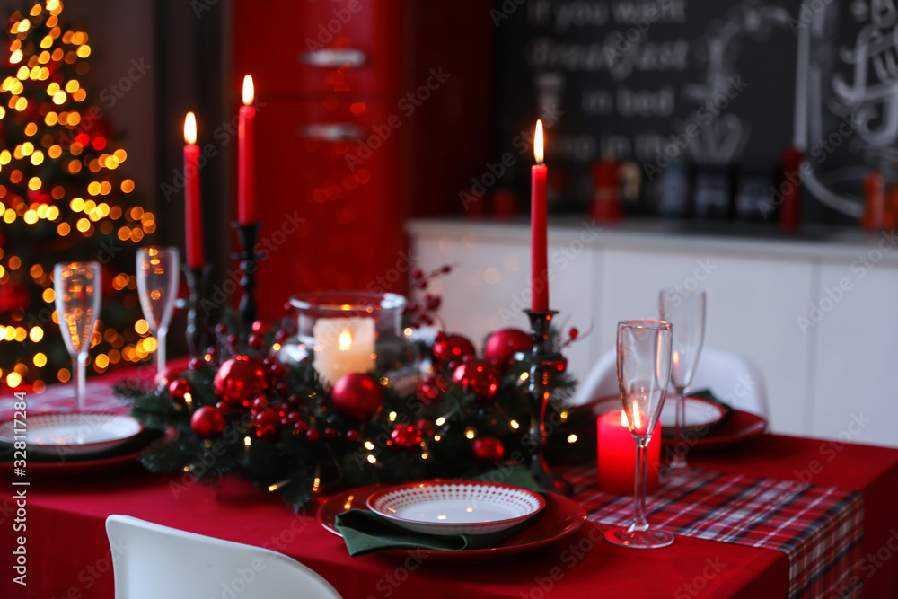 Table served for festive dinner and Christmas tree in stylish kitchen interior Table served for festive dinner and Christmas tree in stylish kitchen interior