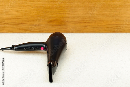 Hair dryer on woody marbled background with copy space