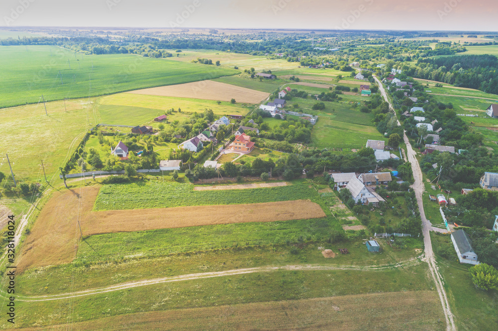 Summer rural landscape. Aerial view. View of green fields, village, and country road