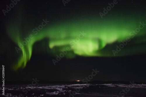 Vivid northern lights over the frozen Nunavik tundra and a truck in the distance(Canada) photo