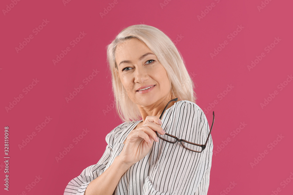 Portrait of beautiful mature woman with glasses on pink background Portrait of beautiful mature woman with glasses on pink background