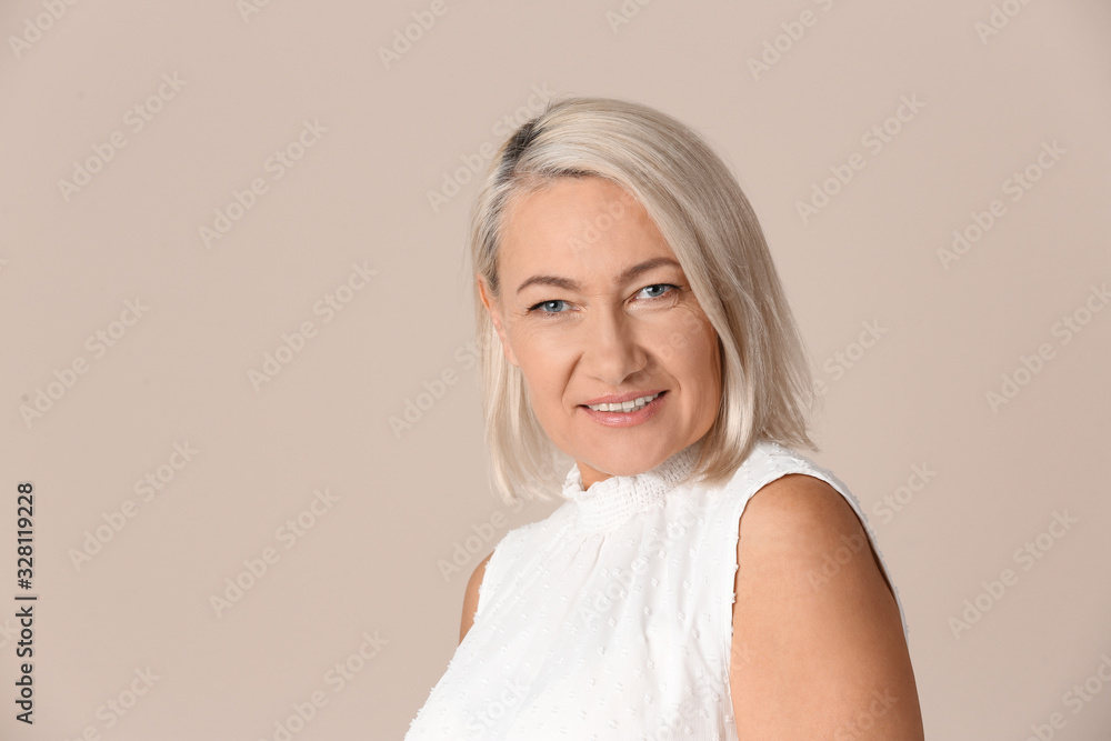 Portrait of beautiful mature woman on beige background Portrait of beautiful mature woman on beige background