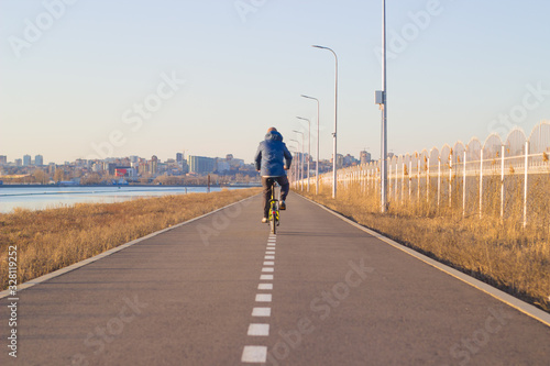 a man rides a bicycle on a cycle track. a bike ride in cold weather.