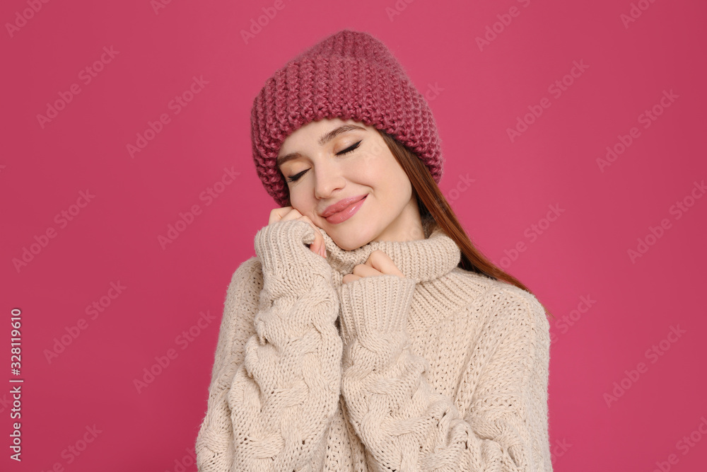 Young woman wearing warm sweater and hat on crimson background. Winter season Young woman wearing warm sweater and hat on crimson background. Winter season