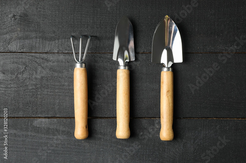 Gardening tools on wooden background, top view