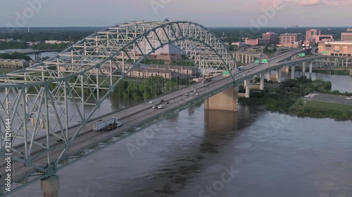 Aerial of traffic on the  Hernando de Soto Bridge crossing the Mississippi River at sunset. In the background is the  Big Cypress Lodge. Memphis, Tennessee, USA. 26 June 2019 photo