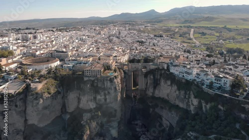 Aerial view of an ancient Spanish city Ronda in Andalucia. Drone flying over the famous bridge Puente Nuevo connecting the two parts of the Old Town, the Plaza de Toros (Bulls square) .