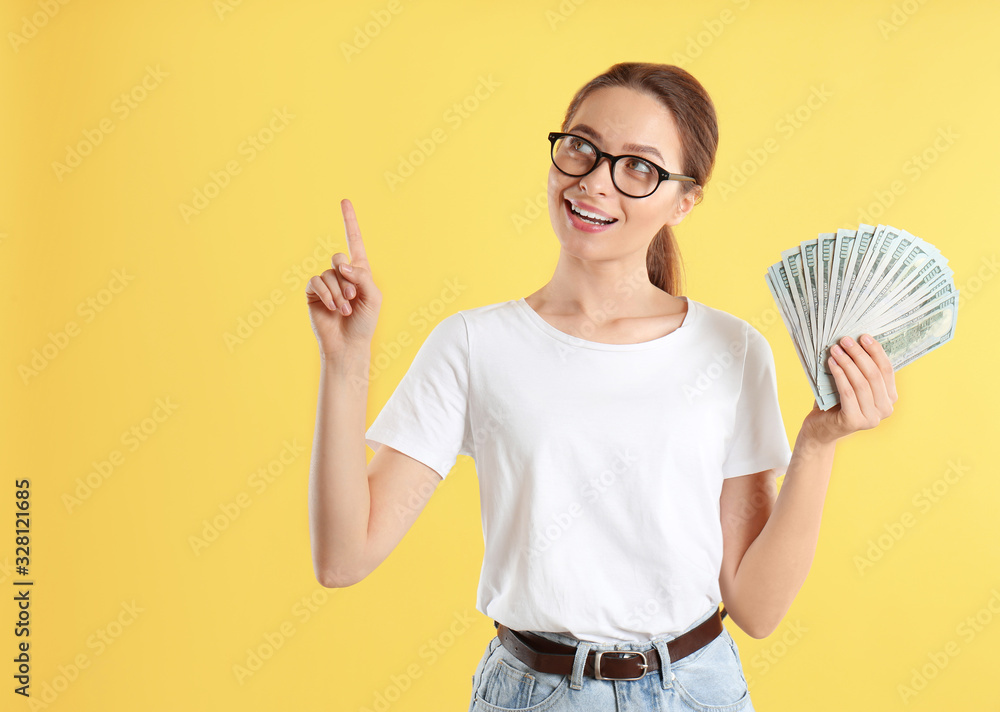 Young woman with money on yellow background Young woman with money on yellow background
