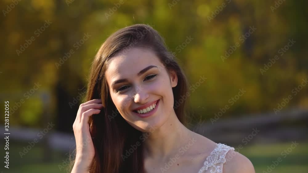 Portrait of beautiful brunette bride is having fun in sunny rays at autumn park Portrait of beautiful brunette bride is having fun in sunny rays at autumn park