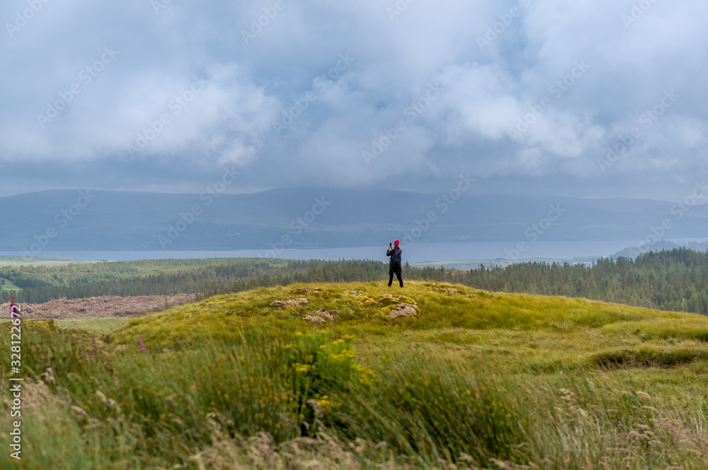 Tourist making photo of scenic Island of Mull landscape. Hebrides, Scotland. Tourist making photo of scenic Island of Mull landscape. Hebrides, Scotland.