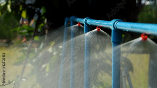 Garden water sprinkler spraying water in garden on a hot summer day