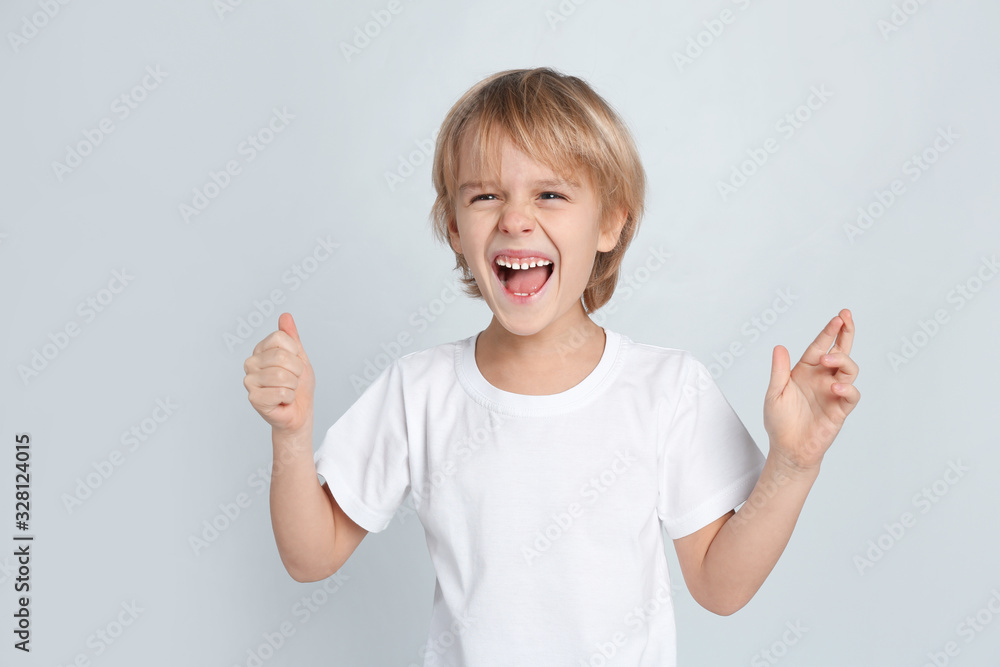Happy little boy on light grey background Happy little boy on light grey background