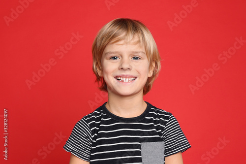 Portrait of happy little boy on red background photo