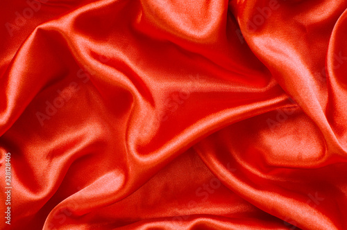 Folds of orange satin fabric.