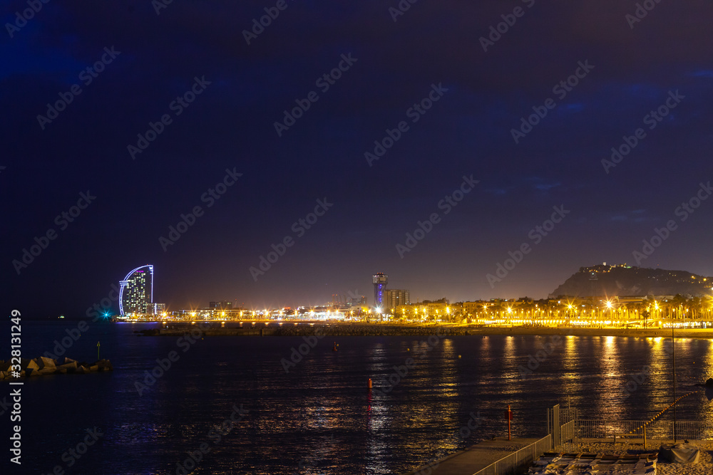 Scenic view of illuminated coastline with Hotel W Barcelona at night, Barcelona, Spain Scenic view of illuminated coastline with Hotel W Barcelona at night, Barcelona, Spain