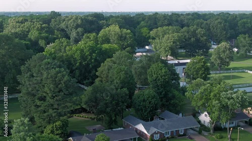 Aerial: Elvis Presley's Graceland, obscured by trees on the property. Memphis, Tennessee, USA. 26 June 2019 photo