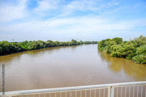 Passing over the bridge over river. The landscape of the river, the surface and the trees of the river's waterplain. photo