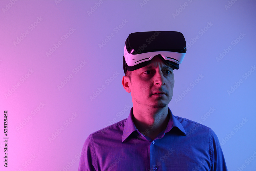 The man with glasses of virtual reality on forehead with neon light. Future technology concept. Modern imaging technology.