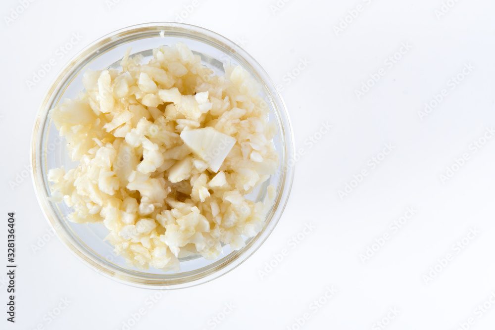 Crushed Garlic in glass bowl. Healthy Food Concept Top View on white background Crushed Garlic in glass bowl. Healthy Food Concept Top View on white background