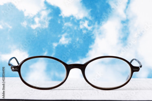 Vintage Eyeglasses Glasses Black Frame smudged against blue cloudy background.