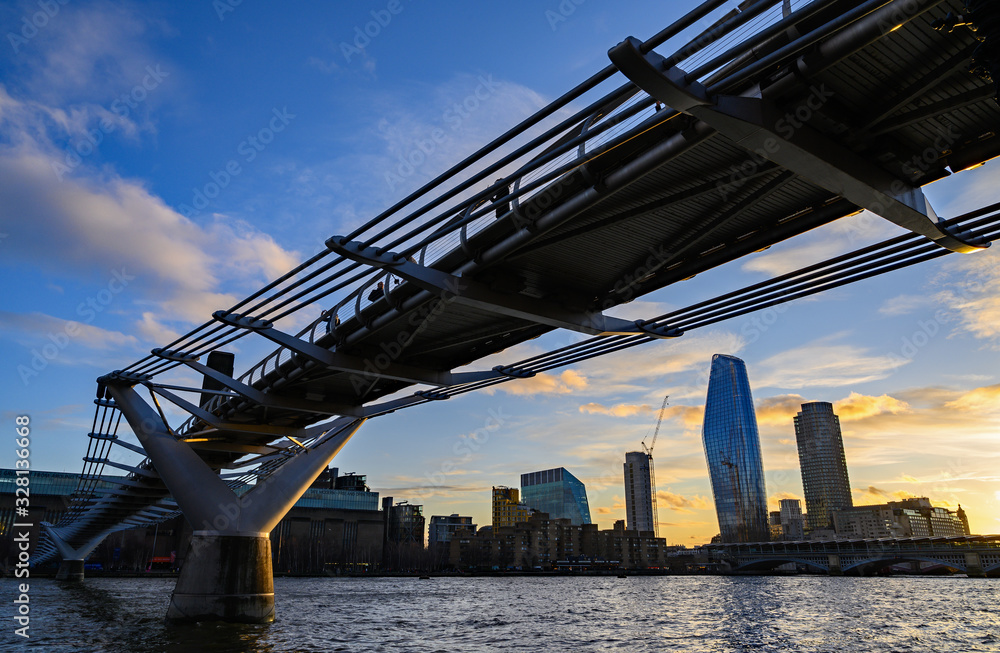 Fototapeta premium The Millennium Bridge in London, UK crosses the River Thames to the Tate Modern gallery with Blackfriars Bridge and the South Bank behind