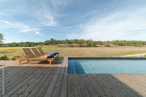 Lounge chairs in modern villa pool photo