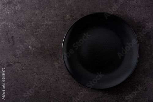 Black plate on black slate top view copy space