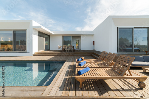 Lounge chairs in modern villa pool © Luis Viegas