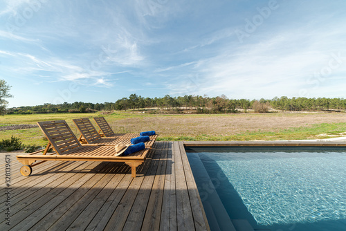 Lounge chairs in modern villa pool