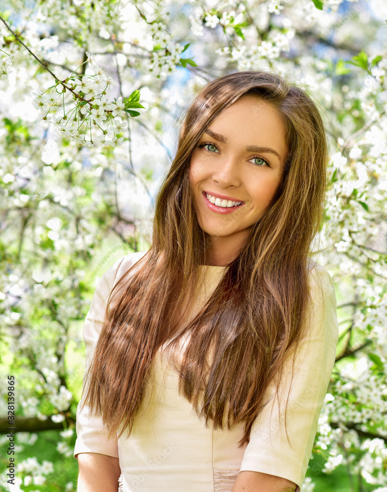 Happy young woman in a flowering spring garden. Spring time. Flowers blossoms. Happy young woman in a flowering spring garden. Spring time. Flowers blossoms.