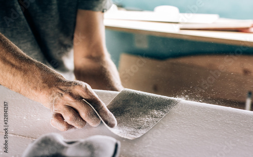 Anonymous shaper making a surfboard