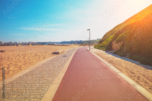 Promenade along the sea and Atlantic ocean in spring. Beautiful bay on a sunny day. View of Porto city on the horizon. Douro Cabedelo Beach, Portugal, Europe