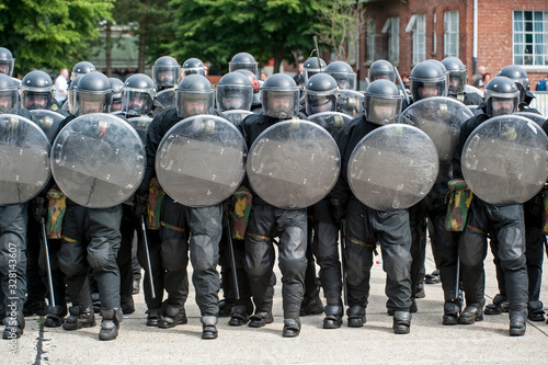 Leopoldsburg, Belgium. May 2011. Demonstration of riot squad forming a protective barrier with riot shields