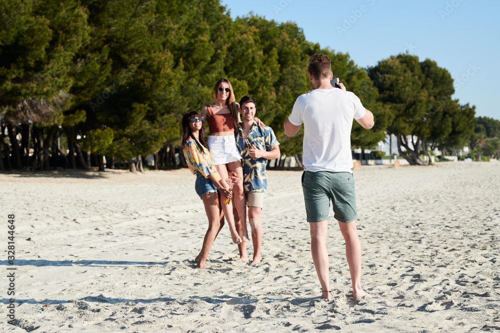 Man taking photo of his friends on beach. Man taking photo of his friends on beach.