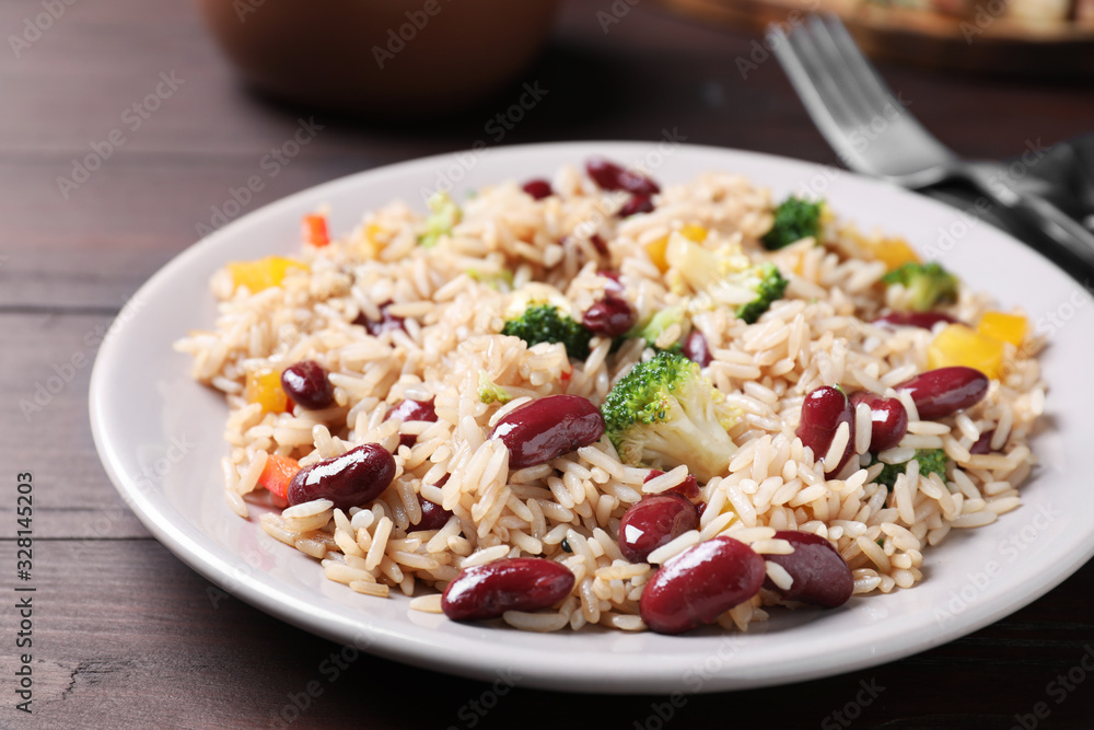 Delicious rice with beans served on wooden table, closeup Delicious rice with beans served on wooden table, closeup